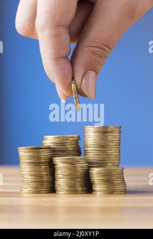 Personne plaçant des pièces de monnaie en pile. Photo de haute qualité Banque D'Images