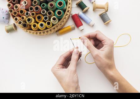 Mains travaillant avec le fil à coudre à aiguille. Photo de haute qualité Banque D'Images