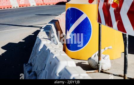 réparation de la route en cours de construction. signe de détour. flèche sur fond bleu Banque D'Images