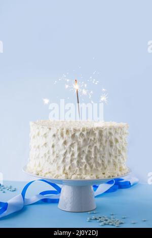 Gâteau d'anniversaire blanc avec un peu de feu de bois Banque D'Images