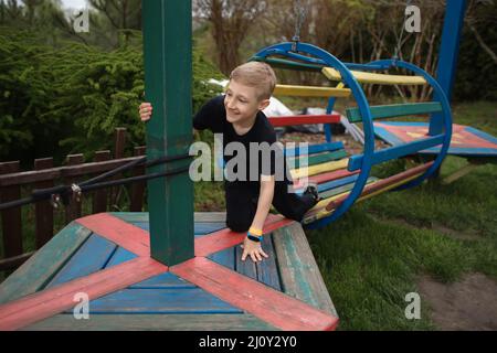 le garçon passe un parcours d'obstacle est engagé dans un sport actif monté sur une plate-forme en bois et s'y tenir Banque D'Images