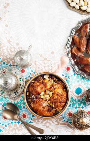 Oum Ali ou Um Ali, cuisine égyptienne dessert du Moyen-Orient. Servi avec du thé, des noix, des fruits dattes. Vue de dessus. Concept Ramadan dessert doux Banque D'Images