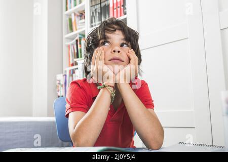 Un enfant mignon assis en pensant. Photo de haute qualité Banque D'Images