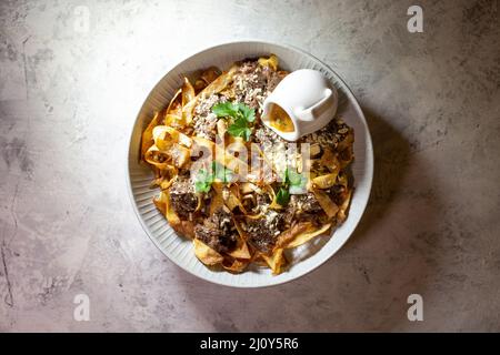 pâtes frites à la viande de cheval dans une assiette blanche. Banque D'Images