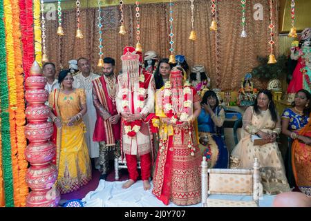 MARIAGE HINDOU la mariée, le marié, les préposés, la famille et les amis pendant la cérémonie du mariage. Dans un temple de Queens, New York. Banque D'Images