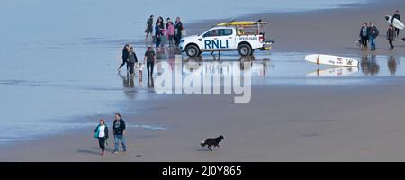 Une image panoramique d'un véhicule d'urgence RNLI et de vacanciers sur la plage de Fistral à Newquay en Cornouailles. Banque D'Images