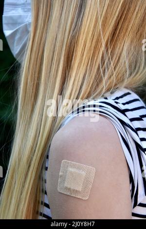 Photo d'une jeune femme blonde avec masque facial ayant pris le vaccin Covid ou corona Banque D'Images