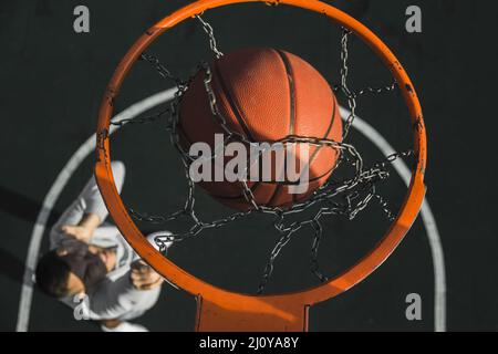 Basket-ball tombant à travers l'anneau. Photo de haute qualité Banque D'Images