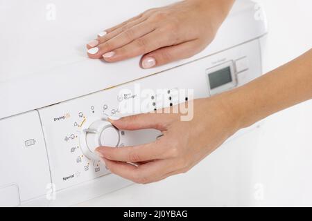 Femme programmant un lave-linge. Photo de haute qualité Banque D'Images