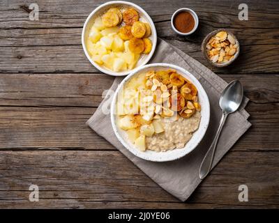 Grand bol de flocons d'avoine savoureux et sains avec pomme pour le petit déjeuner, repas du matin. Banque D'Images