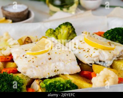 Morue de poisson cuite au four avec des légumes - alimentation saine alimentation saine. Marbre blanc clair Banque D'Images