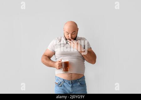 Drôle surpris homme chauve avec bière ventre sur fond clair Banque D'Images