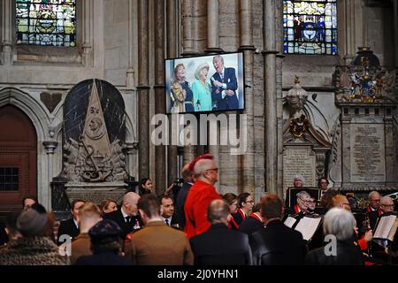 Un écran montrant une photo (gauche-droite) de Petula Clark, Dame Vera Lynn et Bruce Forsyth chantant « nous allons nous rencontrer à nouveau » alors que les gens arrivent pour le Service de Thanksgiving pour les Forces, Dame Vera Lynn à l'abbaye de Westminster, Londres. Le chanteur et animateur a soulevé l'esprit des gens pendant la Seconde Guerre mondiale avec des chansons, y compris nous rencontrerons à nouveau et les falaises blanches de Douvres. Elle est décédée en juin 2020, âgée de 103 ans. Date de la photo: Lundi 21 mars 2022. Banque D'Images