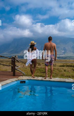 Couple homme et femme dans la piscine de là Lodge pendant les vacances en Afrique du Sud donnant sur les montagnes près de Hermanus Banque D'Images