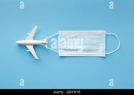 Flat Lay masque médical avec figurine d'avion. Photo de haute qualité Banque D'Images