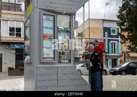 Felanitx, Espagne; mars 11 2022: Stand de loterie de rue de l'organisation nationale espagnole pour les aveugles, UNE FOIS, avec un client portant un masque. Felanit Banque D'Images