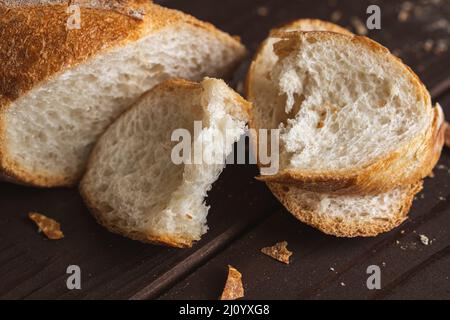 Couper en morceaux de pain de blé frais. Tranches de baguette française. Gros plan Banque D'Images