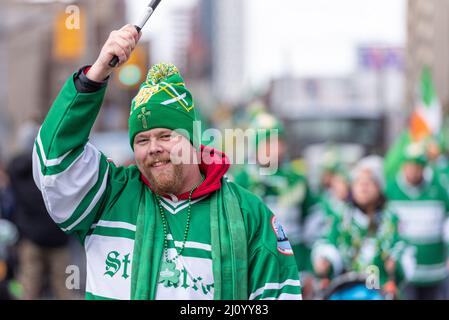 Un homme vêtu de marches vertes et blanches lors des célébrations de Saint Patrick qui célèbre la culture irlandaise de la ville. Le défilé de Saint-Patrick Banque D'Images