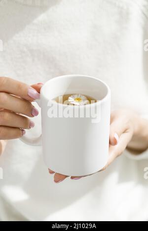 Femme à grand angle tenant une tasse blanche avec du thé Banque D'Images