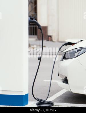 Vue latérale de la voiture en cours de charge de la station de charge de véhicule électrique Banque D'Images