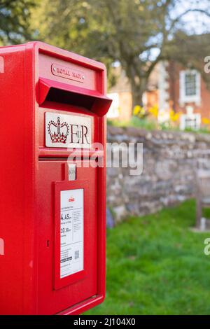 Gros plan de la boîte postale rouge du Royaume-Uni Royal Mail (ER II) isolée à l'extérieur dans le village de campagne anglais. Banque D'Images