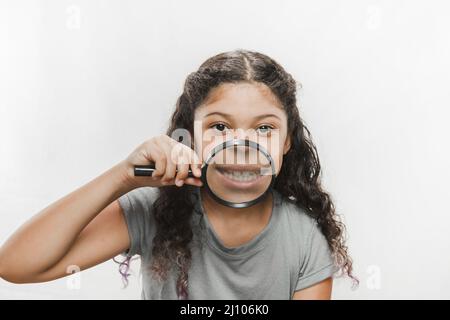 Gros plan fille avec loupe montrant ses dents Banque D'Images