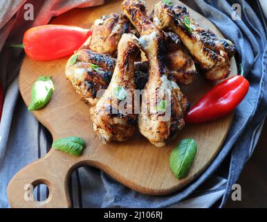Cuisses de poulet grillé sur une planche à découper. Fond rustique Banque D'Images