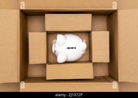 Tirelire en céramique dans des boîtes en carton ouvertes. Concept d'épargne financière. Banque D'Images