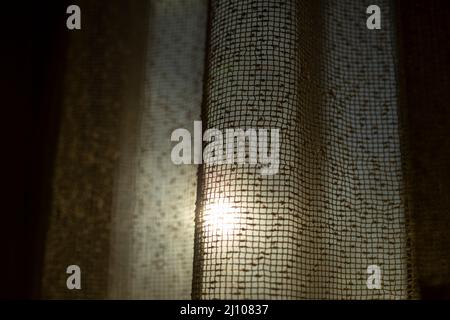 Le soleil brille à travers les rideaux. Rideaux sur la fenêtre. Lumière du matin. Atmosphère fraîche. Banque D'Images