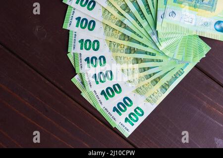 Fan de papier cent billets en euros sur table en bois. Tas d'argent Banque D'Images