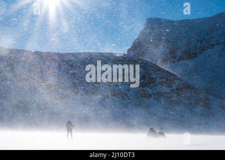 Un seul ski-tourer à la dérive surlignée dans les rayons du soleil dans les montagnes norvégiennes Banque D'Images