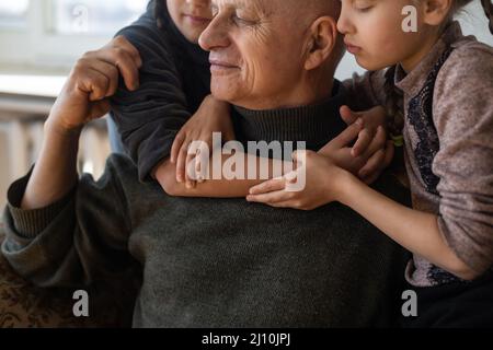 Grand-père ukrainien et deux petites-filles embrassant Banque D'Images
