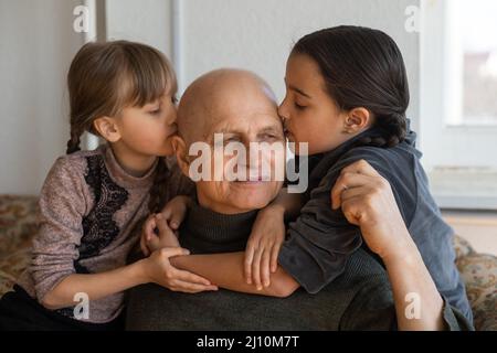 Grand-père ukrainien et deux petites-filles embrassant Banque D'Images