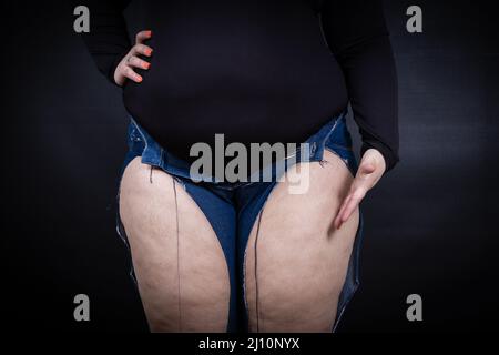 femme grasse en jeans déchirés sur fond noir. Photo de haute qualité Banque D'Images