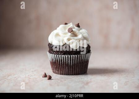 Un riche cupcakes au chocolat avec glaçage à la crème fouettée et chips au chocolat. Banque D'Images