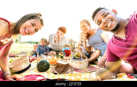 Des familles multiraciales heureuses qui prennent le selfie au pic nic Garden Party - concept de joie et d'amour multiculturel avec des gens de race mixte qui s'amusent ensemble au su Banque D'Images