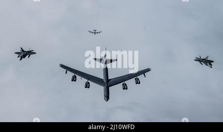 Golfe de l'Alaska, États-Unis. 16 mars 2022. Un bombardier stratégique B-52H Stratosfortesses de la Force aérienne américaine est escorté par des chasseurs F-22 Raptor, affectés à la région NORAD de l'Alaska, survolant le destroyer à missiles guidés USS Curtis Wilbur lors de l'opération Noble Defender le 16 mars 2022 au-dessus du golfe d'Alaska, aux États-Unis. L'exercice du NORAD s'inscrit dans le cadre de récentes initiatives militaires visant à dissuader la Russie de participer en Ukraine. Crédit : SRA Joseph Leveille/États-Unis Air Force/Alamy Live News Banque D'Images