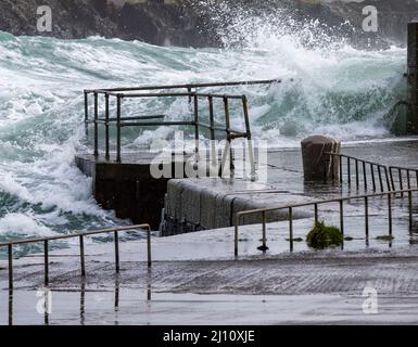 Des ondes de tempête de l'Atlantique se brisent au-dessus des barrières de sécurité des quais Banque D'Images