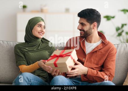 Joyeux mari du Moyen-Orient donnant un cadeau à la femme à la maison Banque D'Images