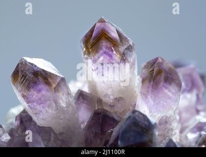 Un cliché macro de l'échantillon minéral d'amétrine brillant pierre géologie roche cristal de pierre avec un fond bleu Banque D'Images