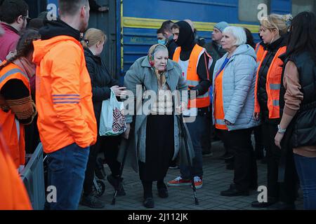 LVIV, UKRAINE - 20 MARS 2022 - une vieille femme marchant avec des béquilles quitte un train d'évacuation de Kramatorsk, région de Donetsk, à la gare Banque D'Images