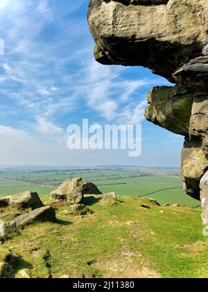 Paysage pittoresque vue sur le ciel bleu sur les champs verts de l'Almscliffe Crag a Millstone Grit outcrop dans la campagne du Yorkshire du Nord. Banque D'Images