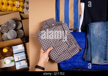 Vue de dessus des boîtes à dons avec vêtements et nourriture. Les bénévoles recueillent des dons. Don, charité, banque alimentaire, aide aux familles pauvres, migrants Banque D'Images
