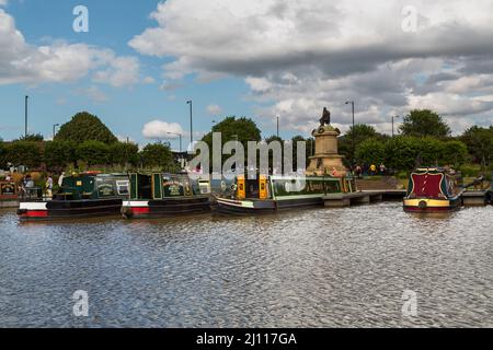 Les touristes apprécient les bateaux étroits colorés amarrés près d'une statue de Shakespeare à Stratford-upon-Avon. Banque D'Images