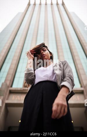 Vous pouvez m'appeler la confiance. Portrait en bas angle d'une jeune femme attrayante debout à l'extérieur de la ville. Banque D'Images