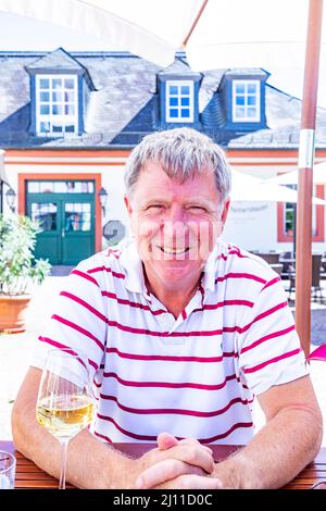 heureux homme mature assis dehors dans un beergarden et aime la vie Banque D'Images