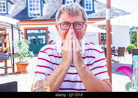 heureux homme mature assis dehors dans un beergarden et aime la vie Banque D'Images