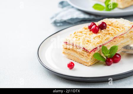 Deux morceaux de gâteau Napoléon sur une assiette blanche. Cuisine russe, gâteau multi-couches avec crème pâtissière, vue rapprochée. Avec espace de copie. Banque D'Images