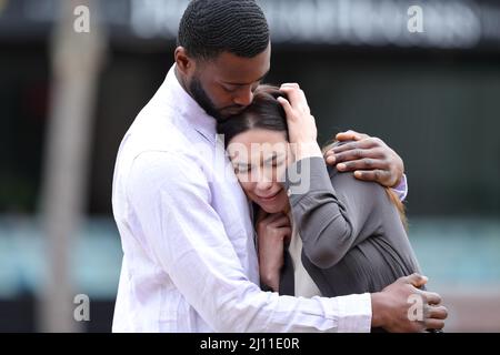 Triste femme étant réconfortée par un bon ami ou partenaire dans la rue Banque D'Images