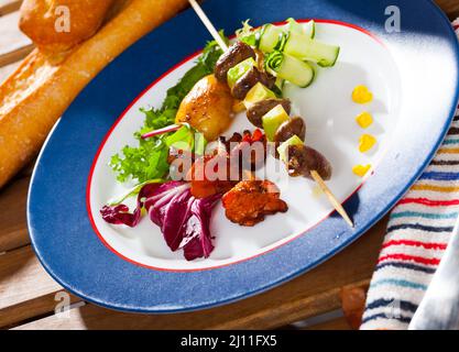 Brochettes de coeur de poulet avec avocat, chanterelles frites, légumes Banque D'Images